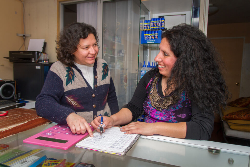 Two women discuss finance, business, and bookkeeping at a small shop in Chile. These entrepreneurs benefited from foreign investment in Chile by Anglo American.