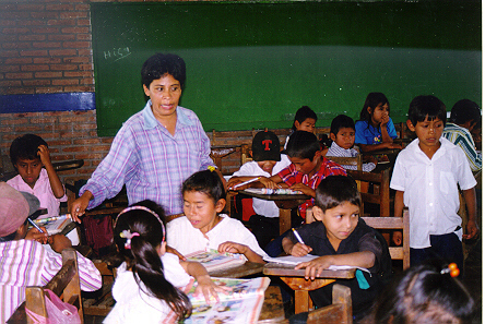 A teacher and children in a classroom.
