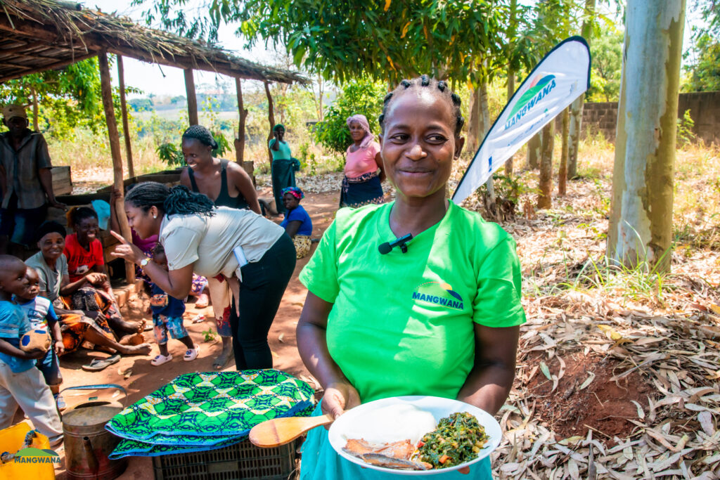 A woman holds a plate of food during a nutrition demonstration as part of TechnoServe’s Mangwana program. (TechnoServe / Flavia Gumende)
