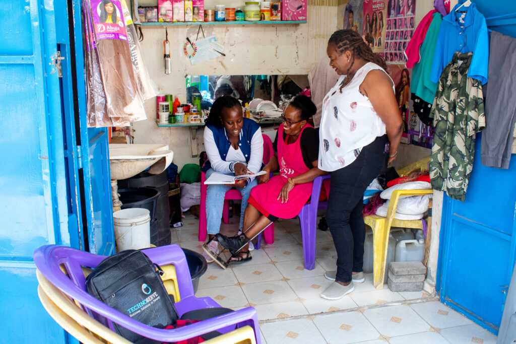 As part of the REWARDS Program, Josephine Mutindi Kitua (center) meets with TechnoServe business counselor Evalyne Kabui (left) and business advisor Agnes Njagi (right) in her salon at Jericho Market in Nairobi. (TechnoServe / Oliver Madara)